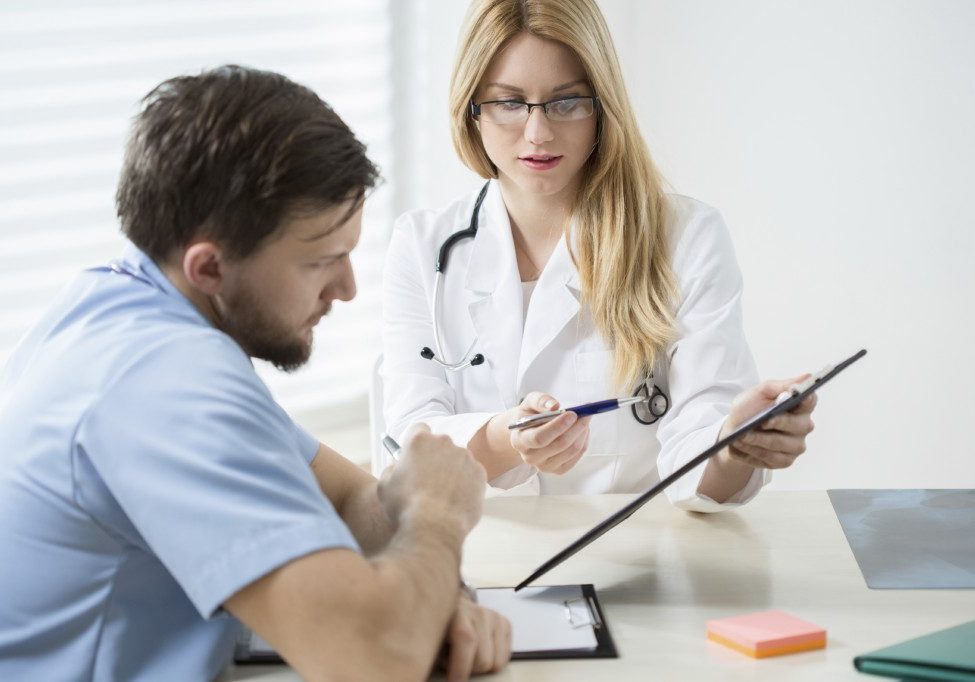 Young female doctor talking with her colleague